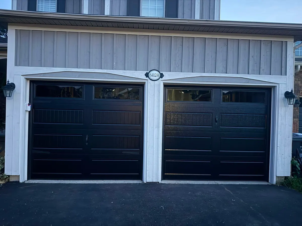 Pair of black carriage-style garage doors with top windows — GTA