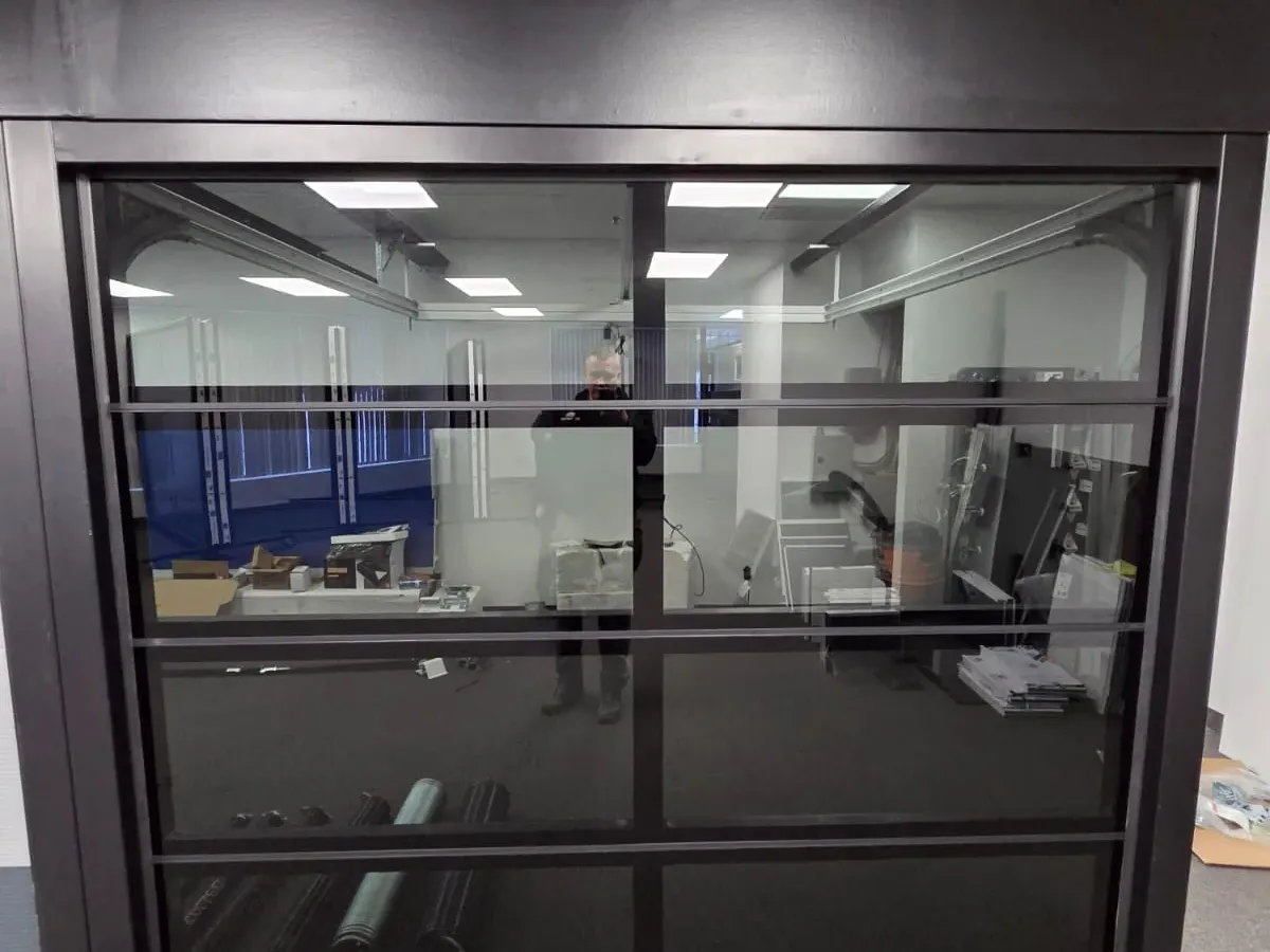 Black full-glass commercial garage door installation — Toronto