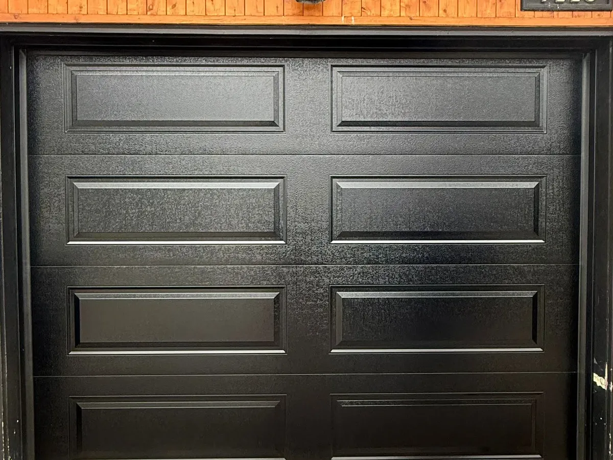 Black raised-panel garage door installation in Toronto