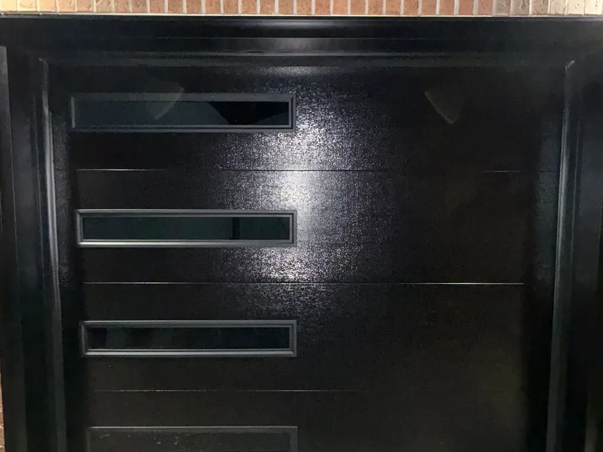 Black single modern garage door with side glass inserts — Toronto